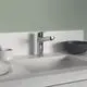 Küchenarmatur von Ideal Standard mit chromfarbener Oberfläche, integriertem Auslauf und modernem Design, montiert auf einer weißen Arbeitsfläche vor grauer Wand.
